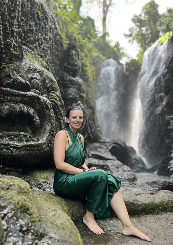 Elvira Nowak sitzend vor einem Wasserfall