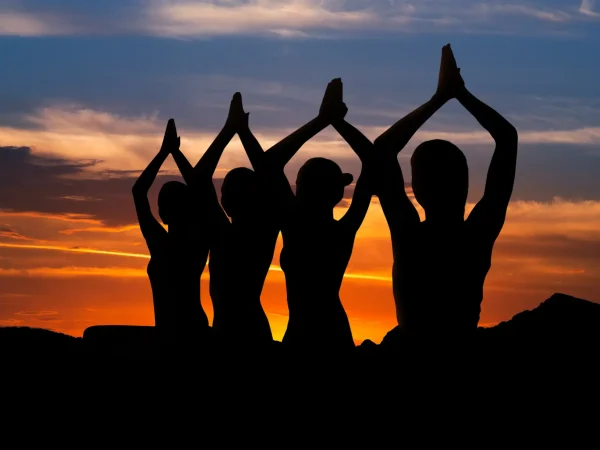 Frauen machen Yoga beim Sonnenuntergang